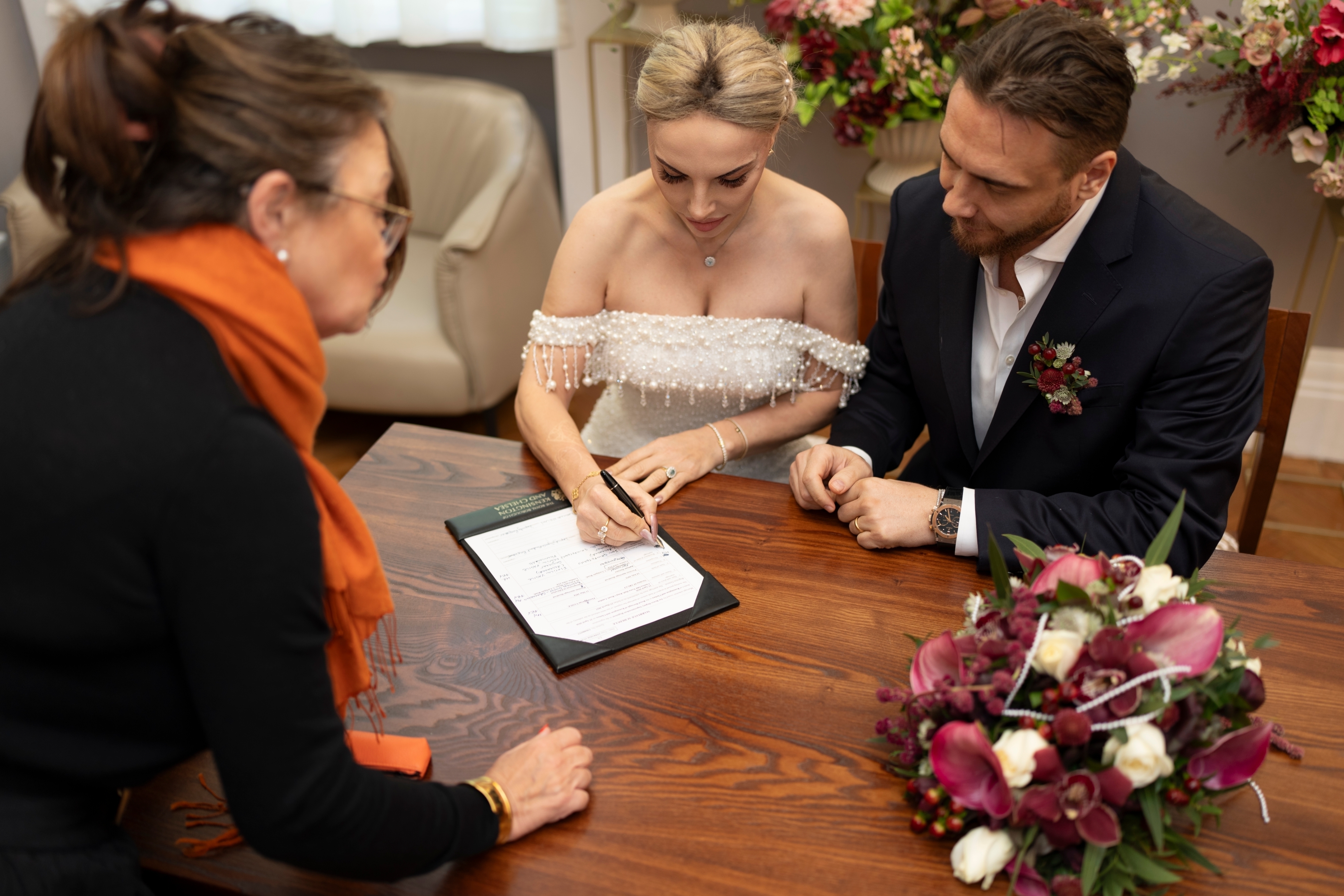 The stylish couple sign their official marriage certificate at Chelsea Old Town Hall.