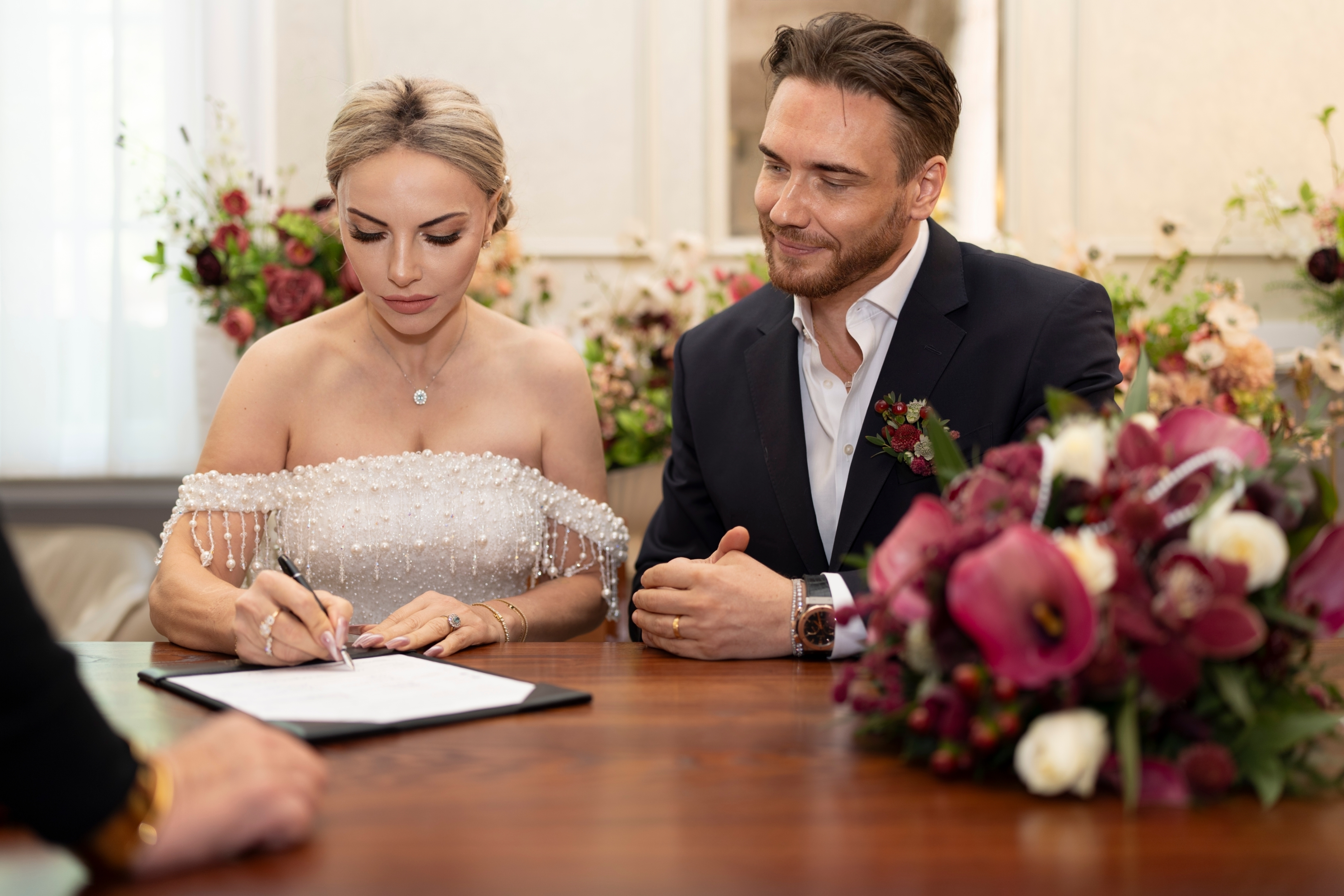 The beautiful bride intently signs the register, officially sealing their union.