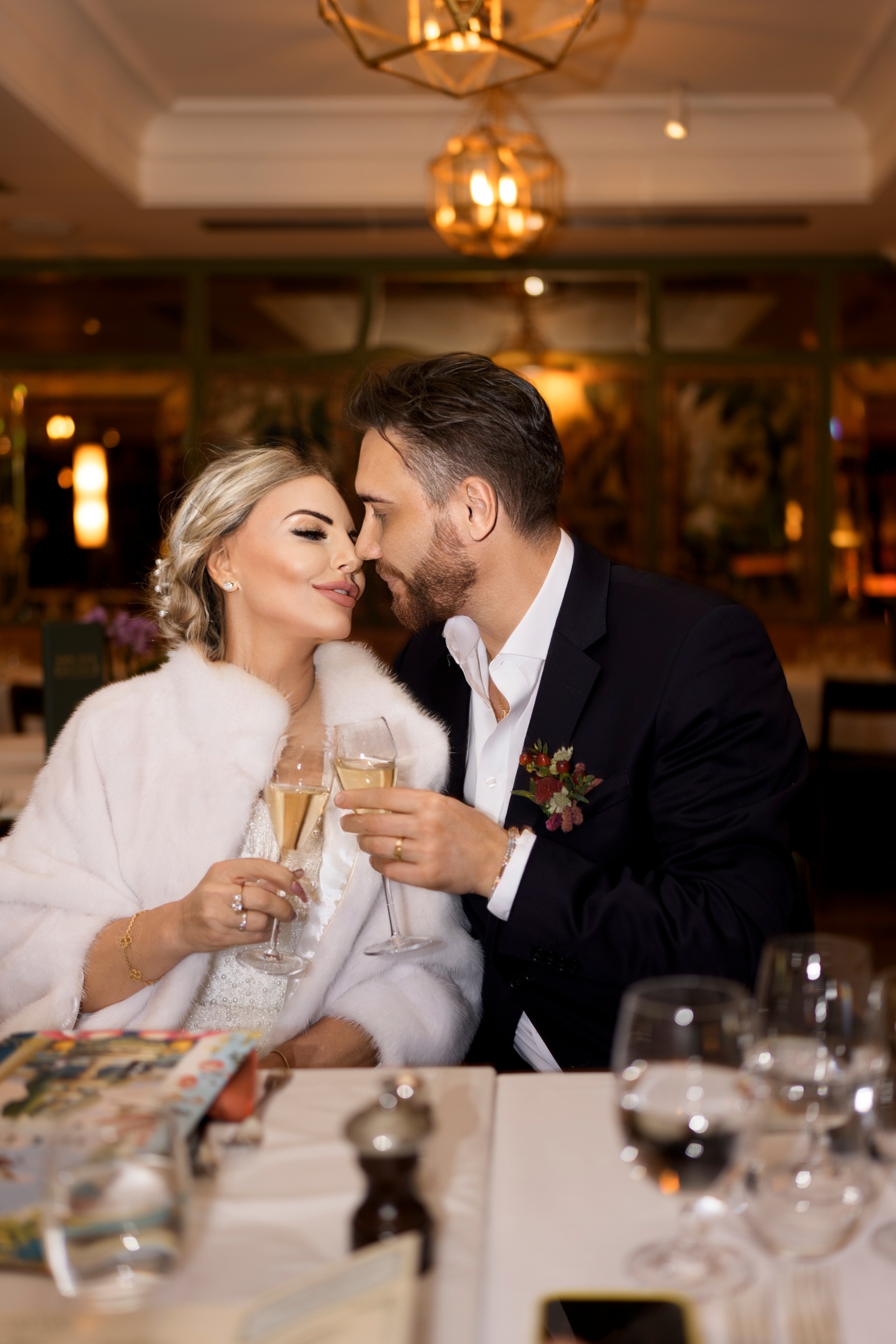The stylish newlyweds share an intimate champagne toast during their wedding celebration.